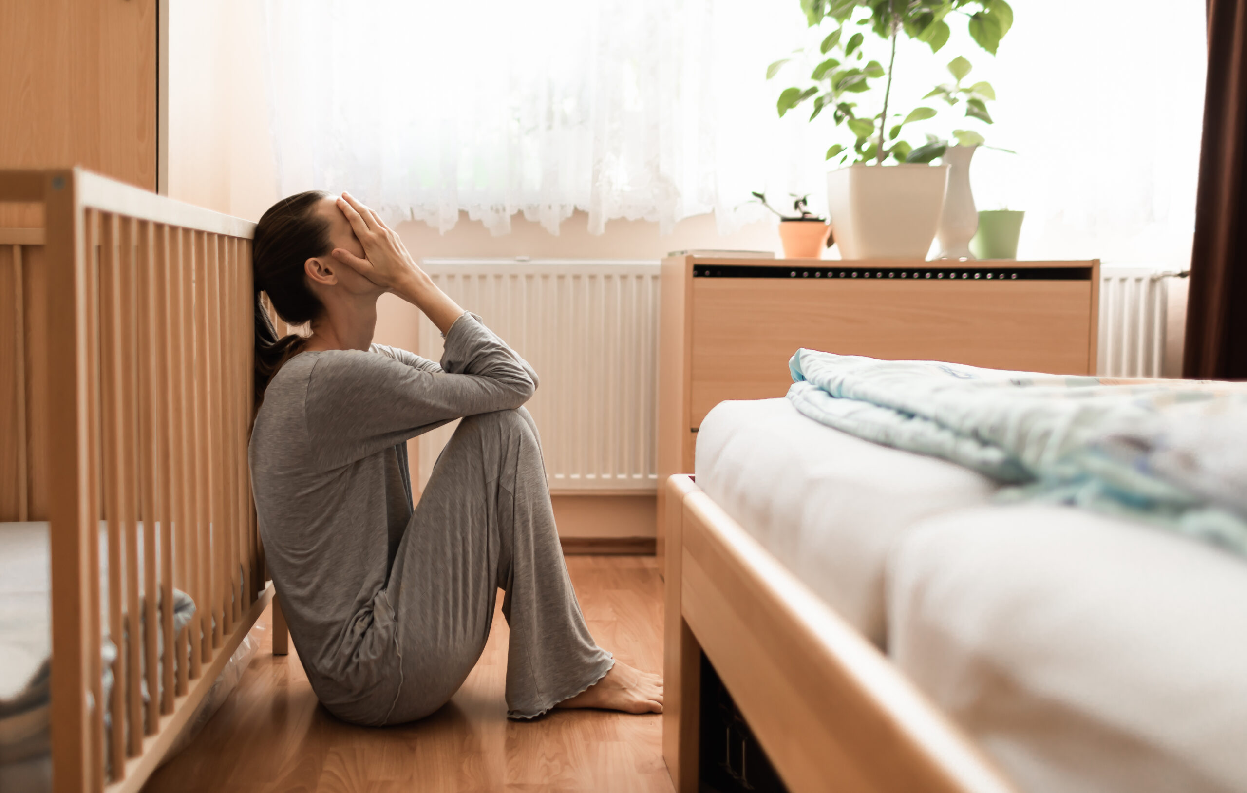 tms for postpartum depression - depressed woman in bedroom concept image.